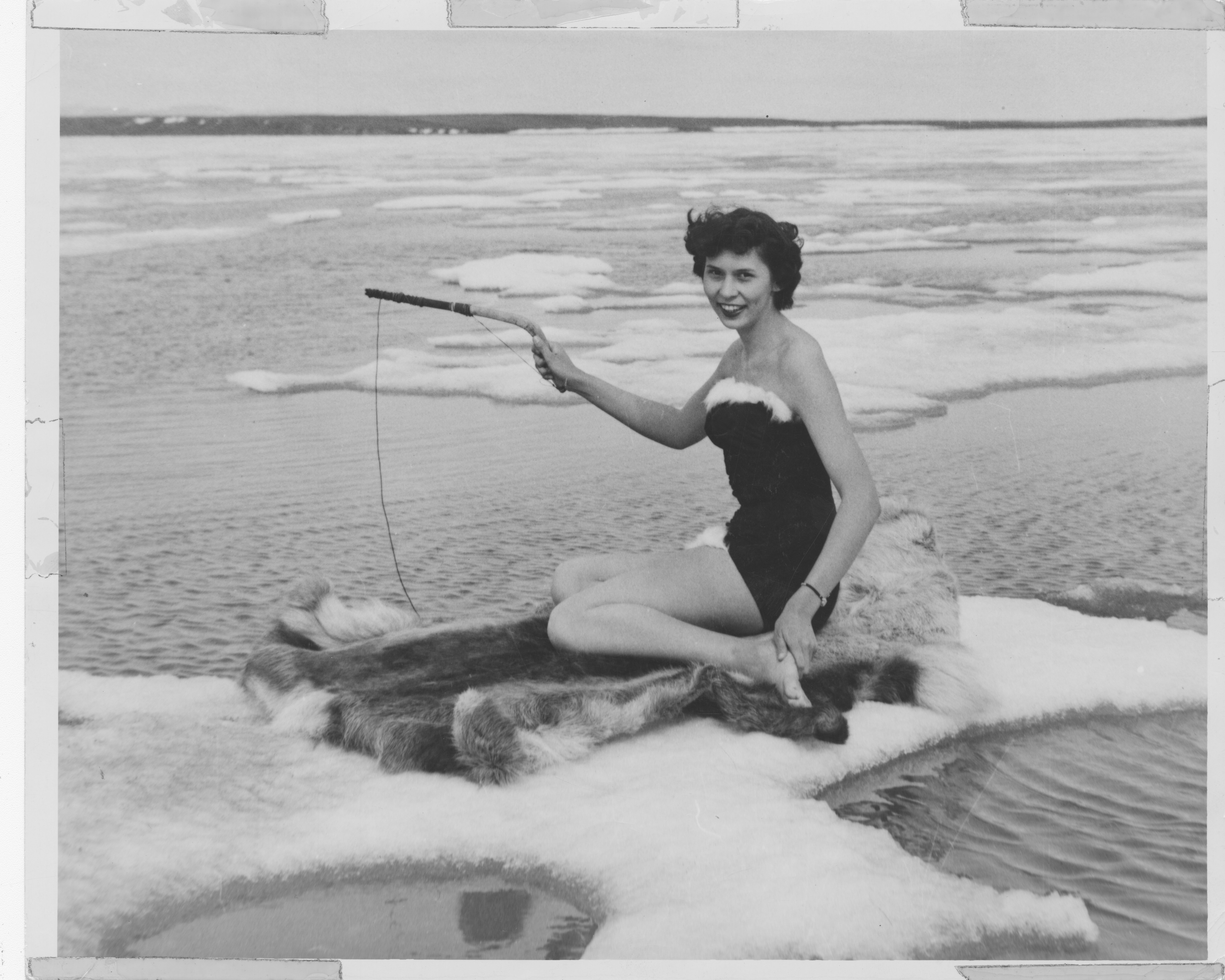 Image of Miss Alaska 1953 Muriel Hagberg, wearing a fur-trimmed bathing suit on iceberg in Kotzebue, 1953