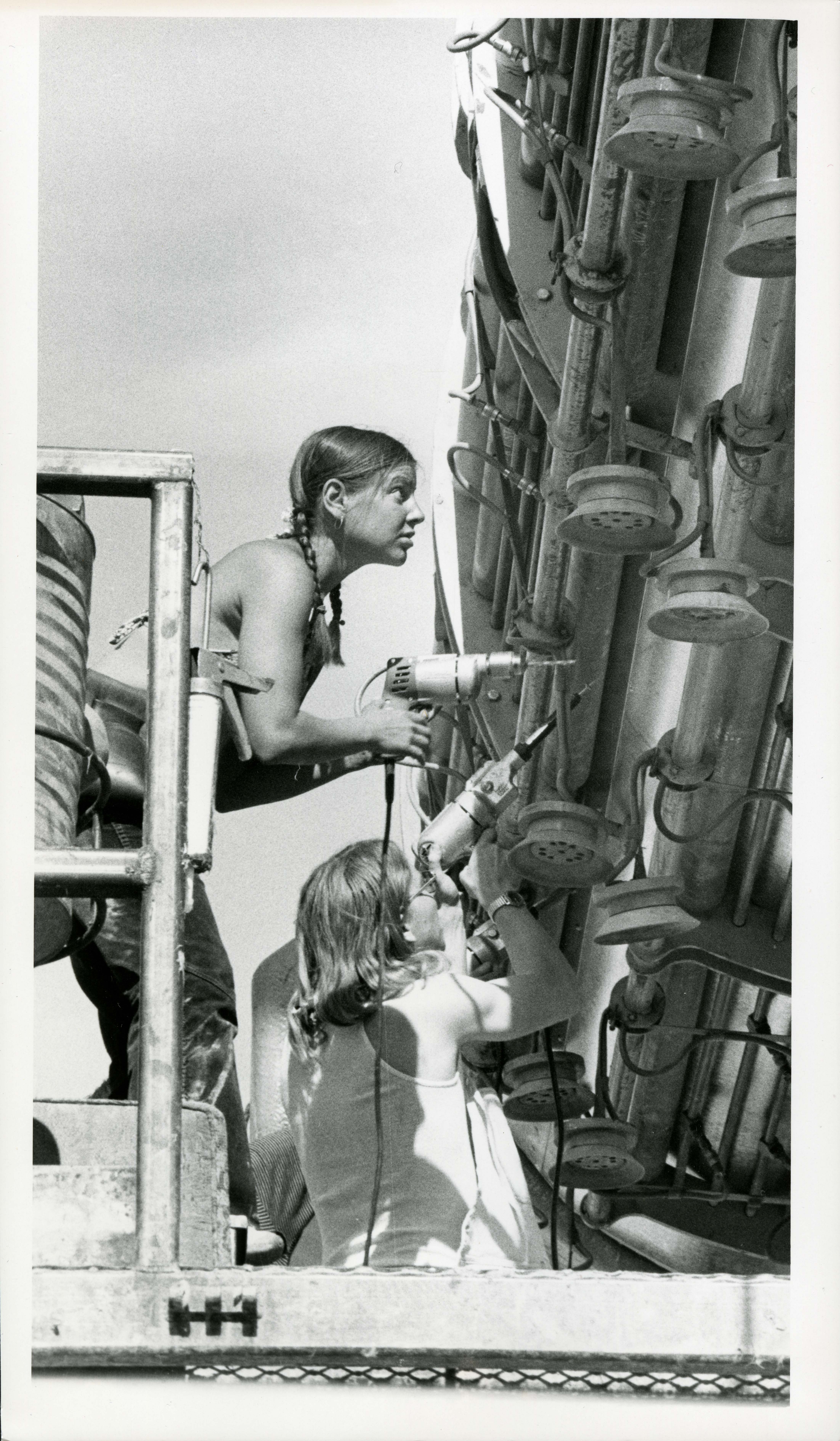 Image of two women working on the pipeline during a warm summer day, c. late 1970s